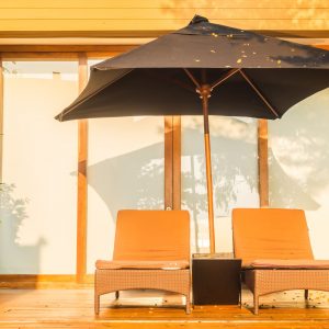 Umbrella and chair around swimming pool in hotel resort - Vacation concept