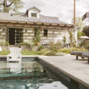 Wooden seats by a pool with parasols